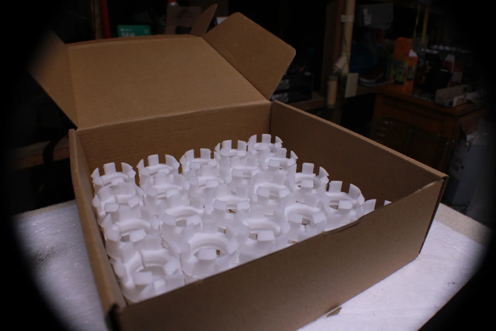 Boîte contenant plusieurs exemplaires de pièces blanches imprimées en 3D